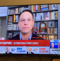 PA attorney general on TV with Sesame Street's Count and toy postal van on bookshelf behind him.