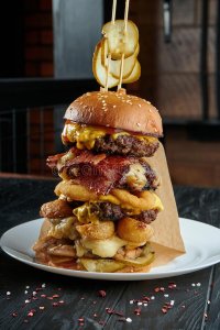 huge-burger-tower-beef-cutlets-melted-cheese-onions-potatoes-cucumbers-sauce-close-up-vertical...jpg