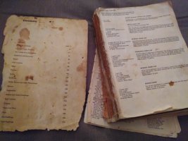 Old book with no cover and falling out pages with food stains