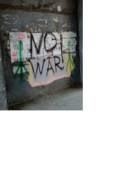 NO WAR! on scruffy grey wall, a simple green peace sign on either side.png