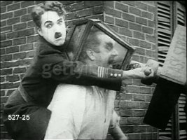 policeman-charlie-chaplin-holding-bent-street-lamp-over-head-of-large-video-id527-25.jpg