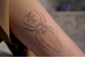 Tattoo of Putin head as spider, with red eyes and bloody mouth. Cyrillic writing..png