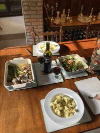 Mushrooms and asparagus, pasta, a dressed salad. Red wine. On a posh table. In a posh house.