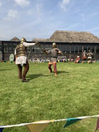 Two grown men dressed up in Roman gear pretending to fight.