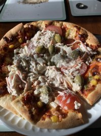 Pizza with coleslaw, tomatoes, olives, dressing. 