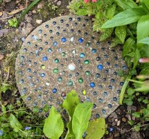 Another stepping stone with concentric circles of coloured glass marbles embedded in the surface 