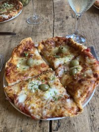 Homemade pizza. It looks great. It’s quite thick, there’s gremalata, and accompanying Prosecco. 