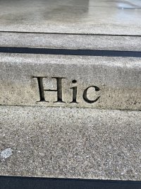 The Latin word “Hic” carved into a step.