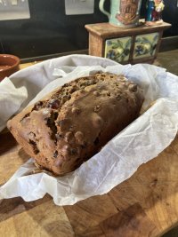 A far from everyday fruitcake sits proudly on a chopping board, glistening with promise and deliciousness. 