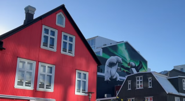 a mural on the gable end of a building showing a lovely polar bear about to eat a puffin