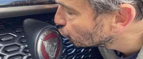 Giles coren kissing the badge on a jaguar