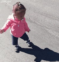 A small child running away from her own shadow