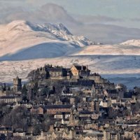 The Old Toun of Stirling atop its hill with castle, and snow-covered hills in the background. 