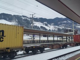 Freight wagons and snow at St Johann im Pongau station with snowy mountains in the background 