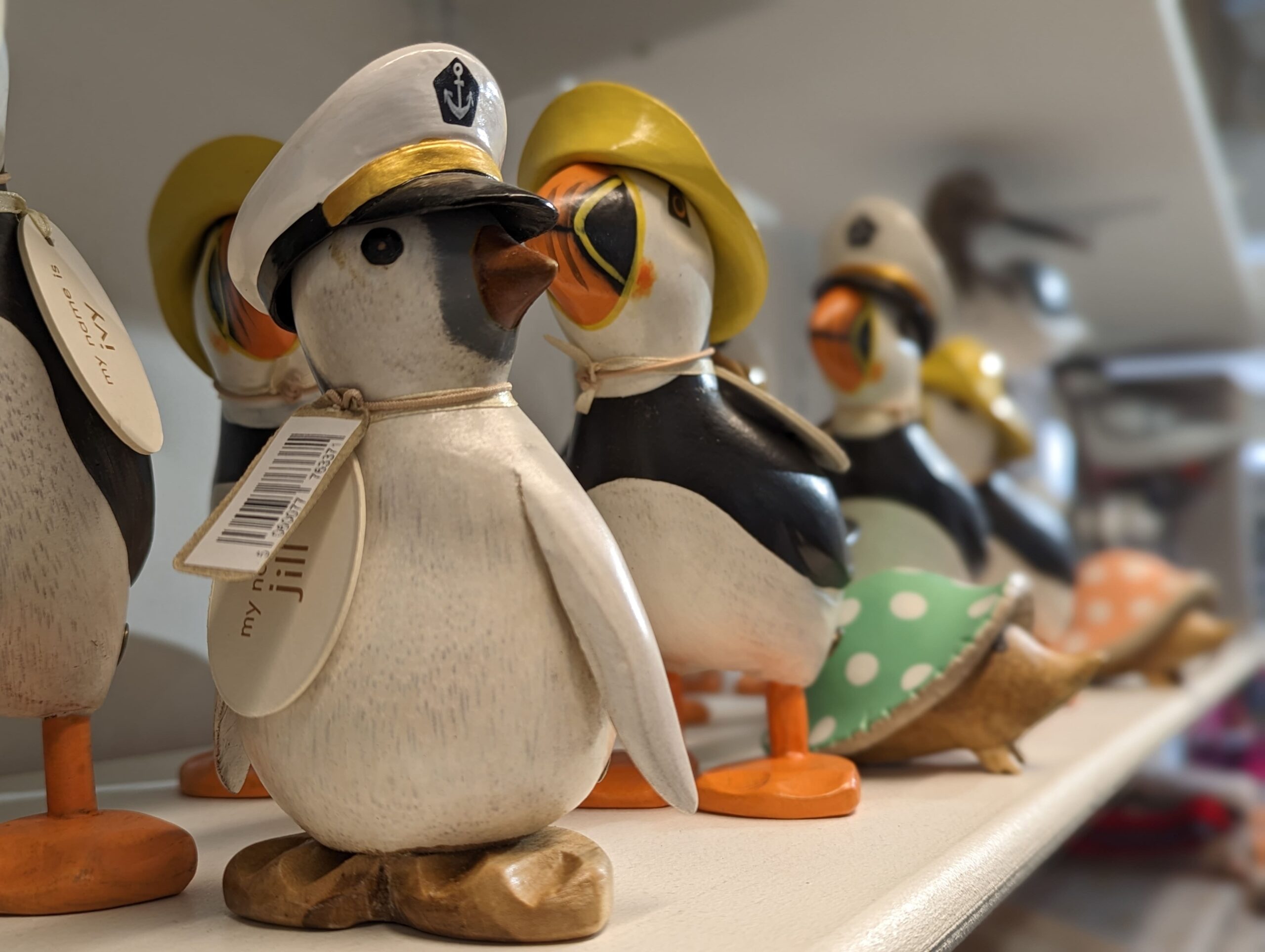 wooden puffins on a shelf in a gift shop