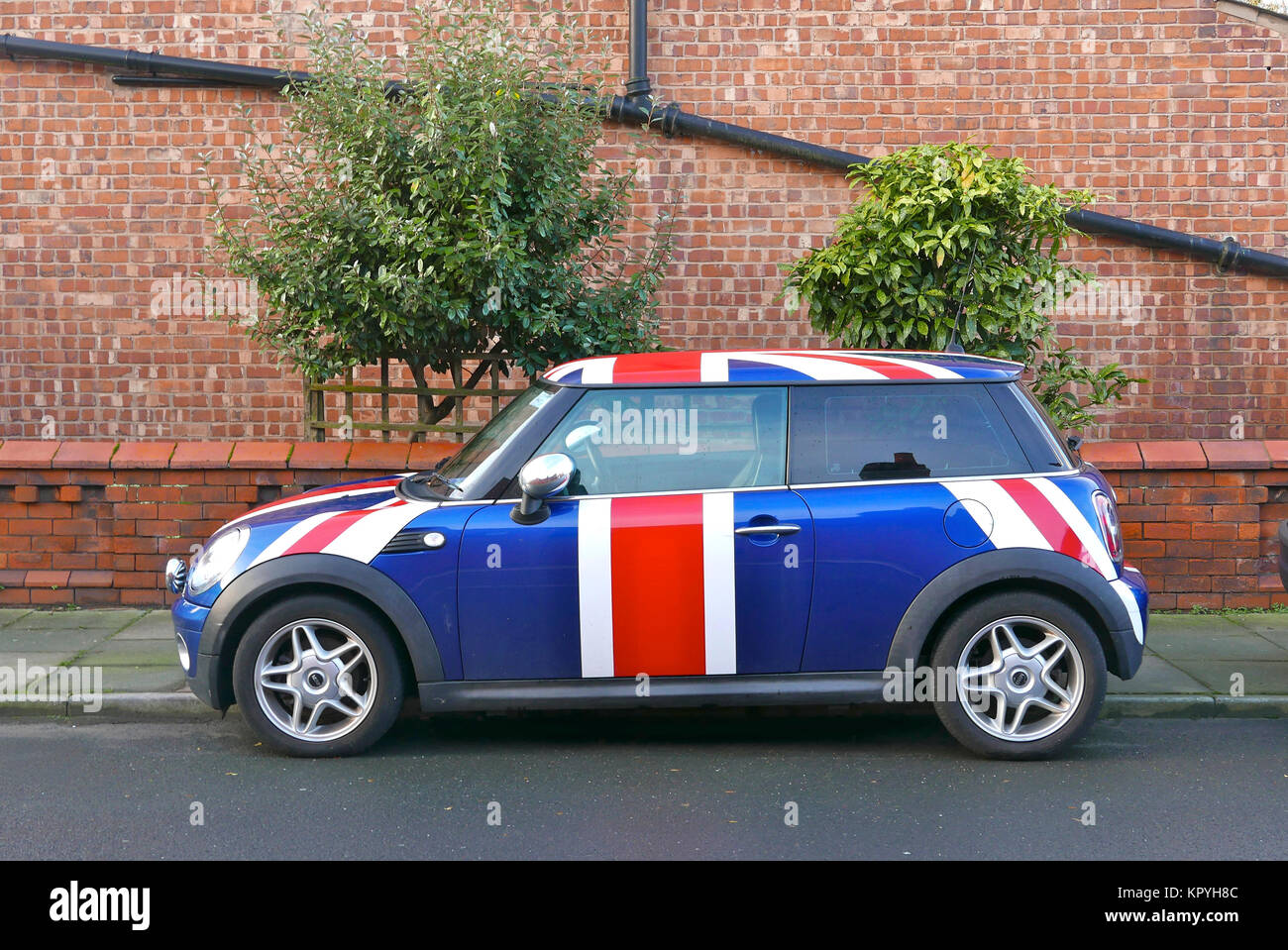 mini-car-in-union-jack-livery-parked-on-road-in-front-of-two-trees-KPYH8C.jpg