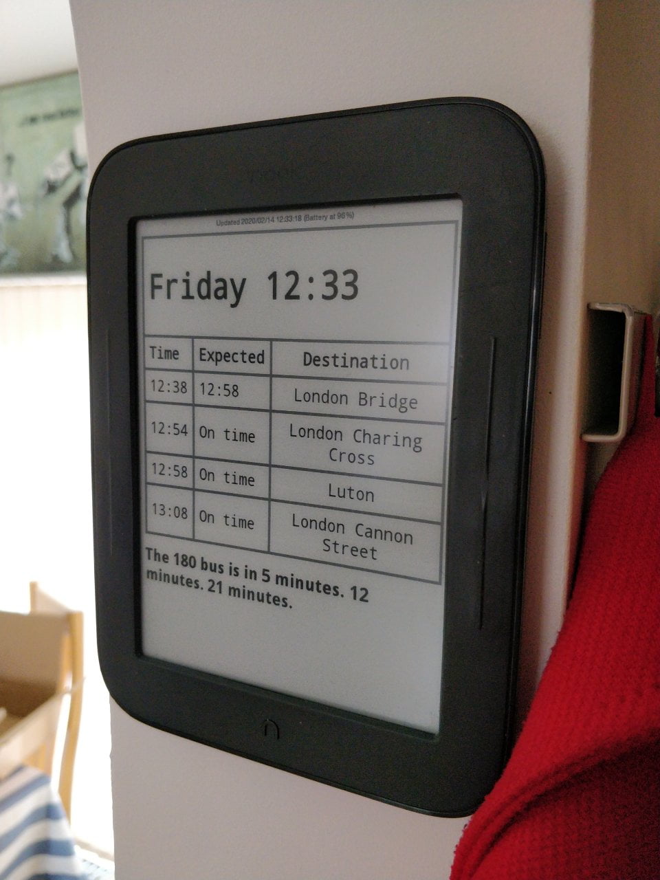 EInk screen showing bus and train times.