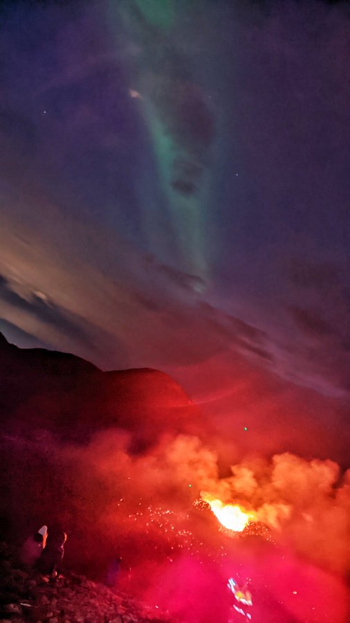 aurora above an erupting volcano in Iceland