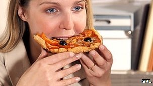 _66776082_pizza_eating_woman.jpg