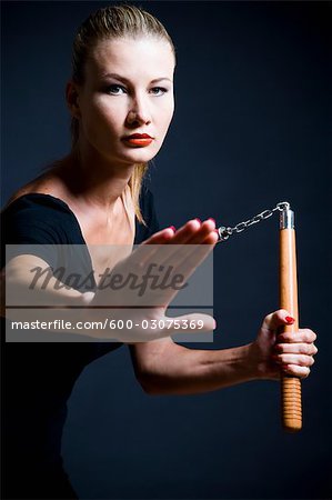 600-03075369em-woman-holding-nunchucks-stock-photo.jpg