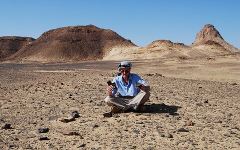 Faulkner in the Jordanian desert holding British Army ration tins found at one of TE Lawrence's camps 