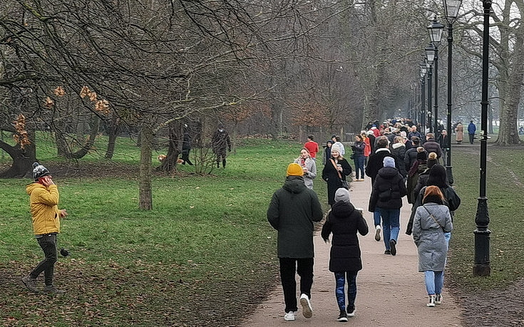 Clapham Common on a winter afternoon: busy crowds, frozen pond and grey skies - photos